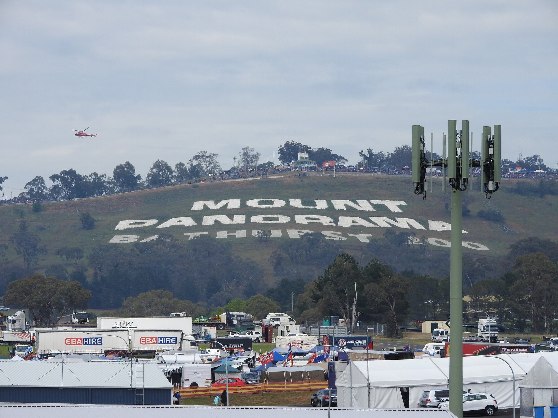 El cartel de Mount Panorama sobre la ladera, con el paddock del Bathurst 1000 abajo.