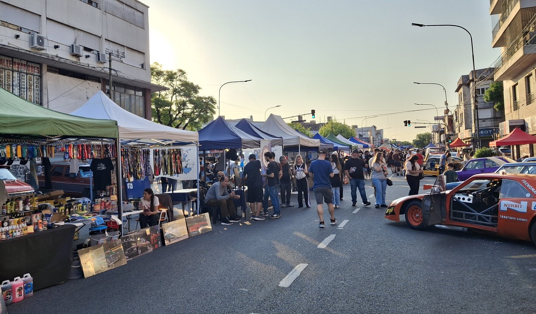 Puestos y autos a lo largo de la calle en la Expo Warnes 2025.