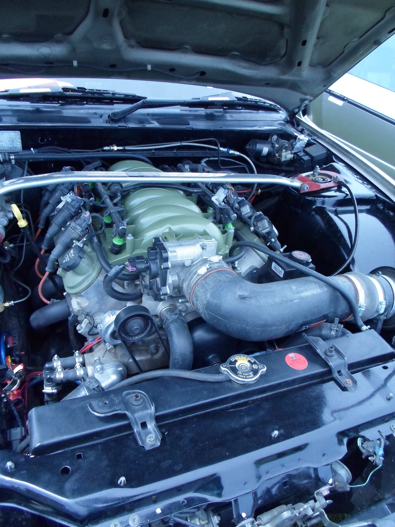 Un V8 de la serie LS trasplantado a un Nissan de 1991, con tapas y admisión pintadas al tono del auto.